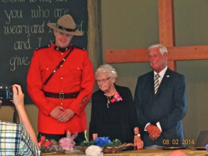Mary Agnes standing at head table with Constable Pankratz and Mayor Armitage