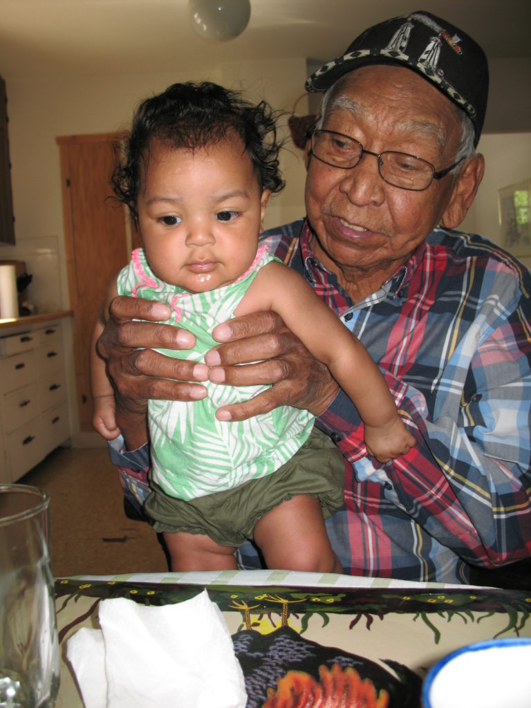 John Terbasket holding his great granddaughter Nia